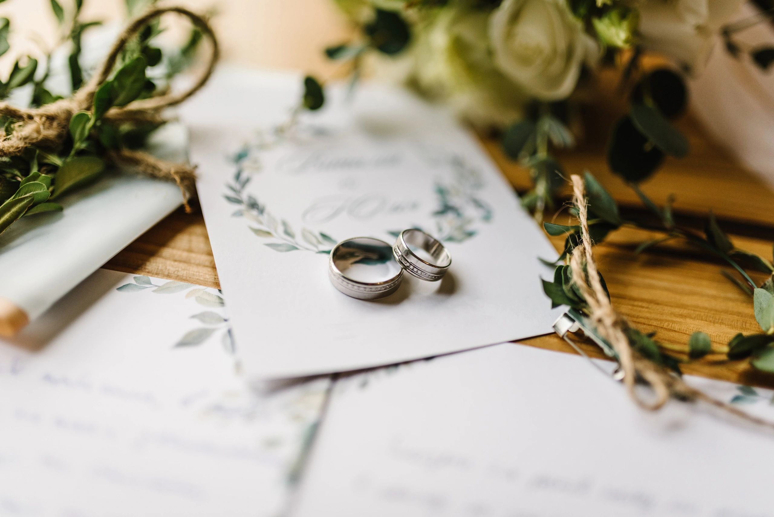 Wedding rings and flowers styled on a tabletop with elegant details