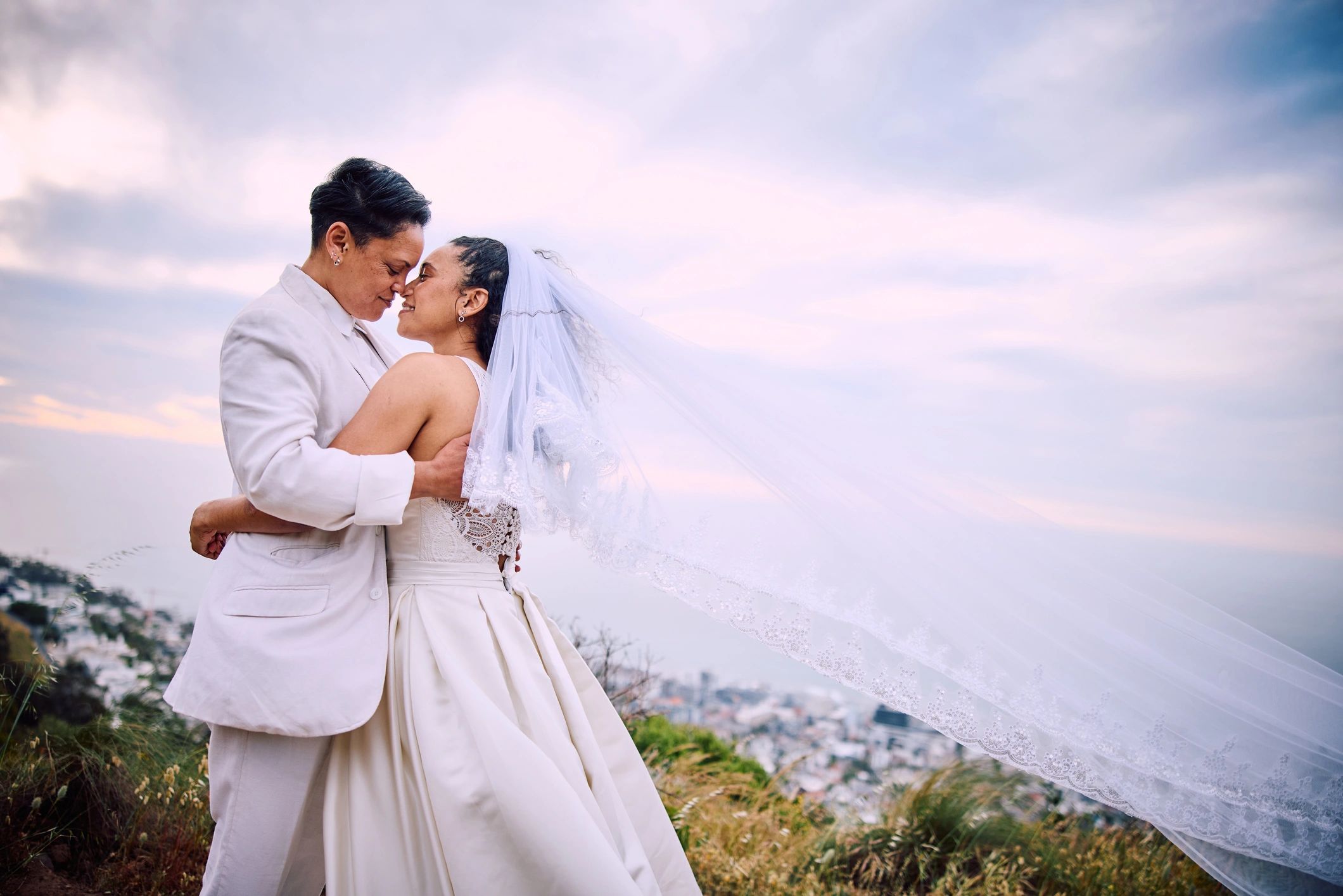 Newlywed couple embracing outdoors in a scenic wedding setting